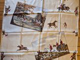 a table cloth with a picture of horses and jockeys on it