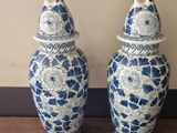two blue and white vases sitting on top of a wooden table