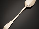 a close up of a spoon on a table with a black background