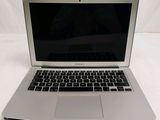 a silver laptop computer sitting on a white surface