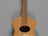un gros plan d'une guitare en bois sur fond gris