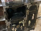 une armoire noire et dorée avec une porte vitrée