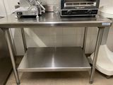 une table en acier inoxydable sur laquelle se trouvent un grille-pain et un autre grille-pain