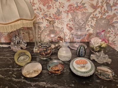 une table sur laquelle se trouvent une lampe, des vases et d'autres objets