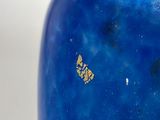 a blue vase with a gold butterfly on it
