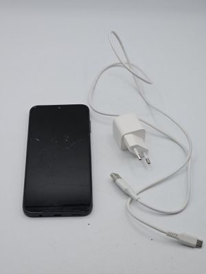 a cell phone and a charger on a white table