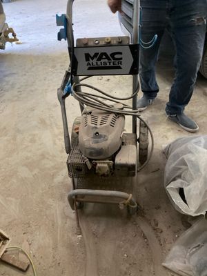 a man standing next to a machine that is on the ground