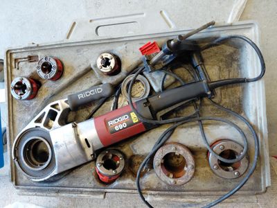 une boîte posée par terre, avec des outils dessus