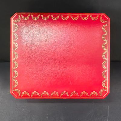 plateau de service rouge et doré, orné d'un motif décoratif sur le devant