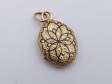 a gold plated pendant with a flower design on it