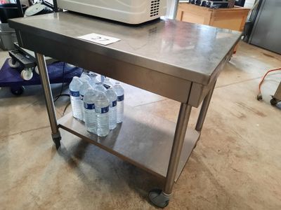 a table with water bottles and a microwave on top of it