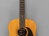 un gros plan d'une guitare acoustique sur fond gris