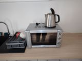 a microwave with a kettle on top of it on a counter