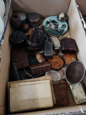 une boîte remplie de vieilleries posée par terre