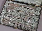 de l'argenterie dans un coffret posé sur une table recouverte d'une nappe bleue