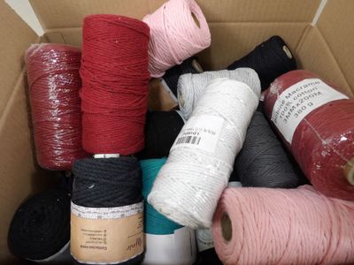 several spools of different colored yarn are in a box
