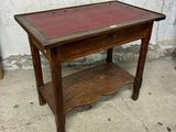 une petite table en bois avec un plateau rouge posée sur un trottoir