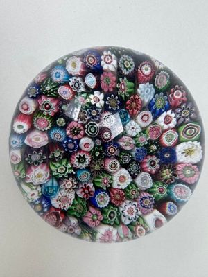 une photo d'un presse-papier en verre orné de nombreuses fleurs