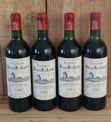 three bottles of red wine are lined up on a wooden shelf
