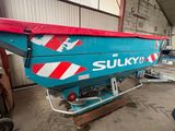 une photo d'un bateau bleu et rouge dans un entrepôt