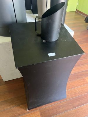 une table noire sur laquelle est posé un vase noir