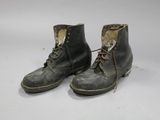 an old pair of boots with laces on them on a white surface