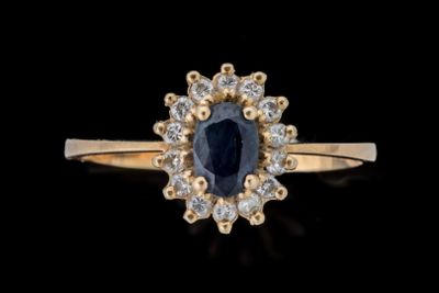 Gros plan sur une bague en saphir et diamants sur fond noir
