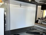 une cuisine équipée d'une cuisinière, d'un évier et de casseroles et poêles posées sur le plan de travail