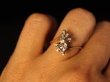 a woman ' s hand with a diamond ring on it