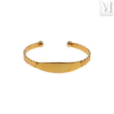 un gros plan d'un bracelet plaqué or sur fond blanc