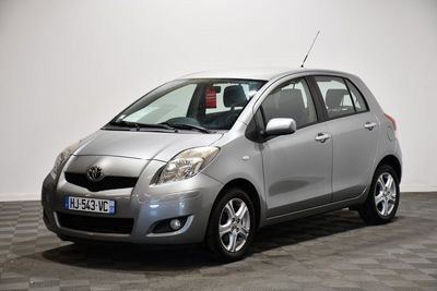 une photo d'une toyota yaris argentée garée sur un sol en damier