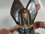 a person holding a small statue of an elephant in their hand