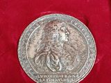an old silver medal in a red velvet case