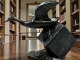 une statue représentant un oiseau perché sur une table