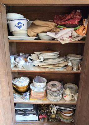 un placard rempli d'assiettes et de bols dans une cuisine