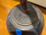 a black object with a red handle on a wooden table