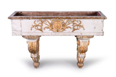 une jardinière blanche et dorée posée sur une table