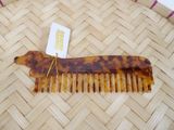 a tortoise shaped comb with a tag attached to it