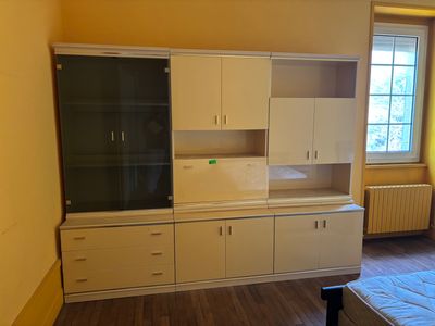 une photo d'une chambre à coucher avec un lit et des armoires