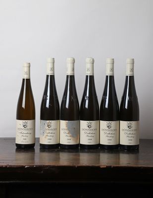 six bouteilles de vin sont alignées sur une table en bois