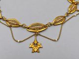 a close up of a gold necklace with a cross and a star