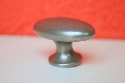 un bouton argenté posé sur une table blanche, sur fond rouge