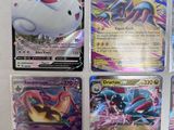 several pokemon cards sitting on top of each other on a table