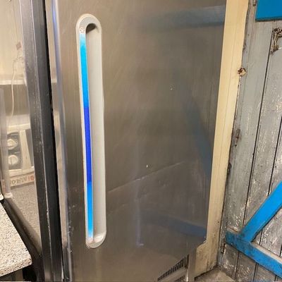 un réfrigérateur en acier inoxydable avec une lumière bleue sur la porte