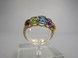 gros plan d'une bague en or avec des pierres multicolores
