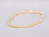 the beaded bracelet is made of bone beads with a white bead