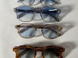 three pairs of glasses sitting next to each other on a white surface