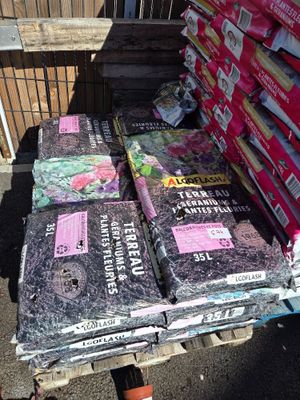 many bags of gardening seed sitting on a pallet