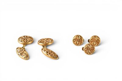 a pair of gold cufflinks and a pair of earrings