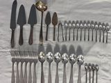 beaucoup de cuillères et de couteaux-cuillères sur une table